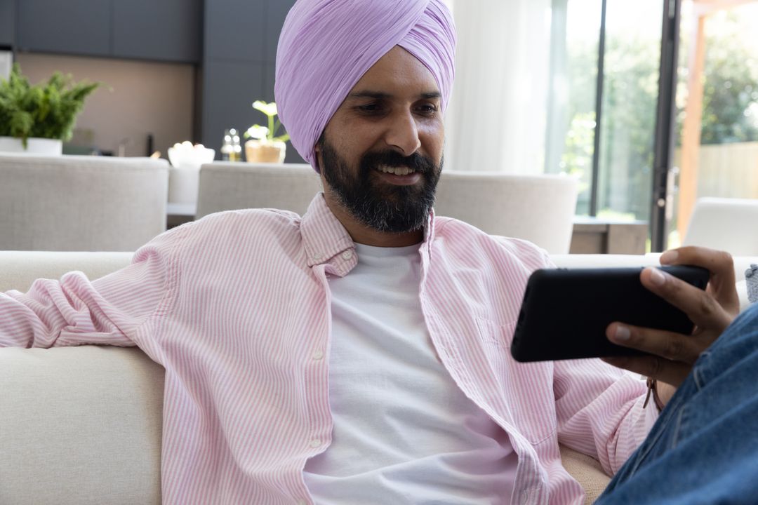 Man Relaxing on Sofa with Tablet in Modern Well-lit Living Room