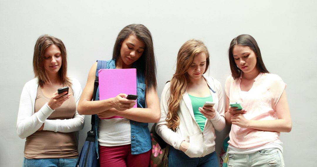 Group of Teenage Girls Using Smartphones Standing Against Wall - Free Images, Stock Photos and Pictures on Pikwizard.com