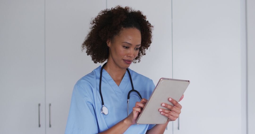 Portrait of biracial female doctor using tablet and smiling - Free Images, Stock Photos and Pictures on Pikwizard.com