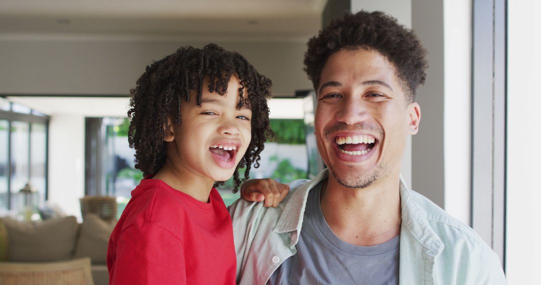 Portrait of happy biracial man and his son looking at camera and smiling - Free Images, Stock Photos and Pictures on Pikwizard.com