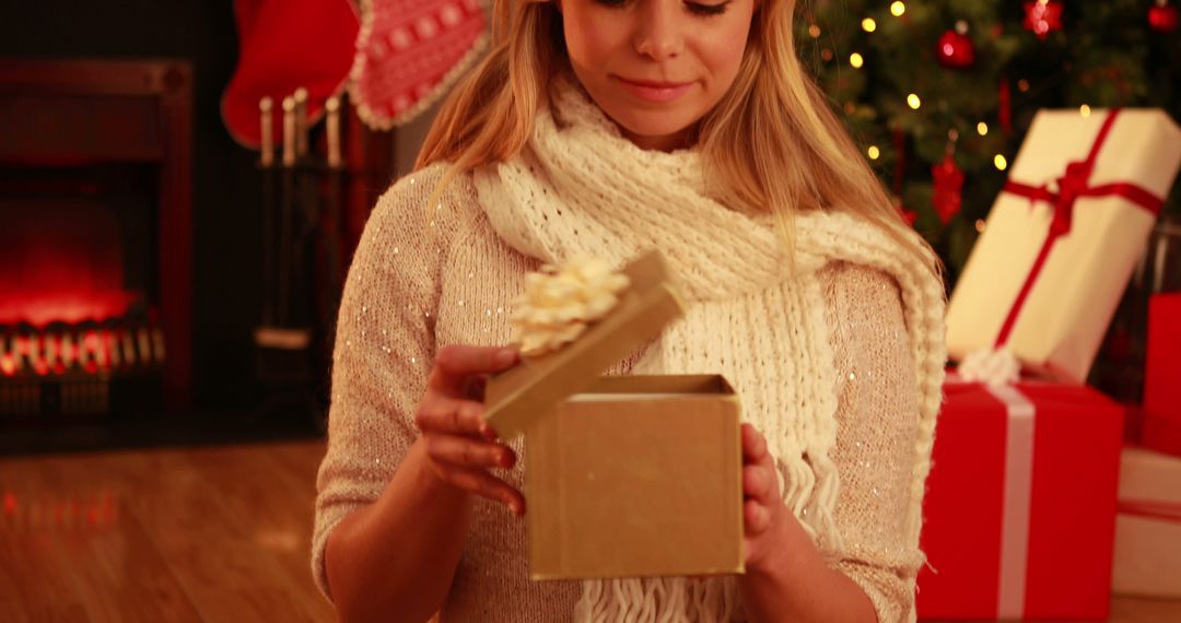 Smiling Woman Opening Gold Gift Box by Christmas Tree - Free Images, Stock Photos and Pictures on Pikwizard.com