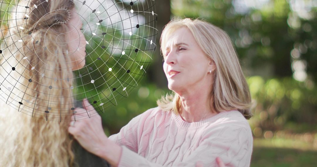 Woman in pink sweater comforting companion in garden with netted headpiece