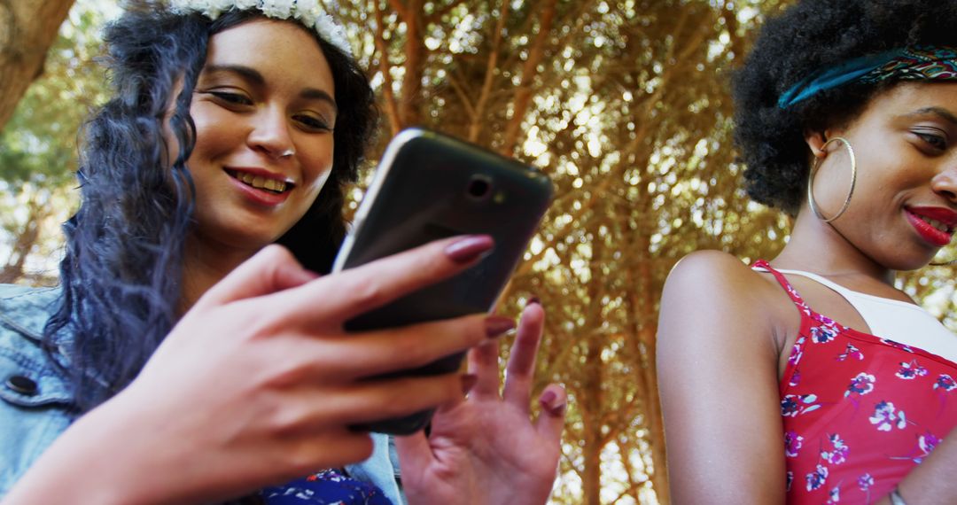 Smiling Young Women Using Smartphone Outdoors - Free Images, Stock Photos and Pictures on Pikwizard.com