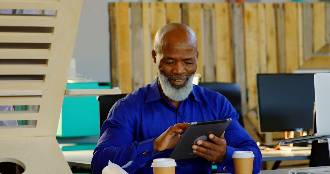 Elderly man using digital tablet in modern office workspace - Free Images, Stock Photos and Pictures on Pikwizard.com