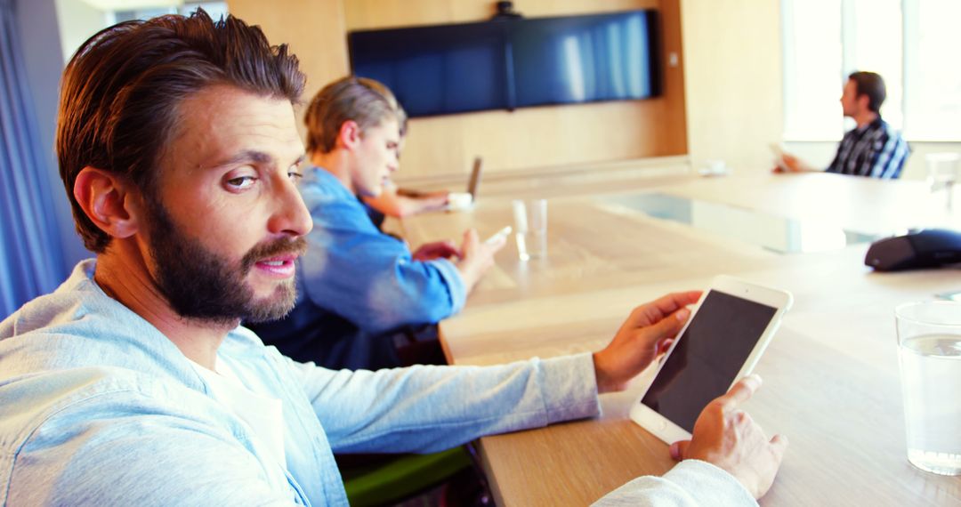 Business Meeting in Modern Office With Professionals Using Tech Devices