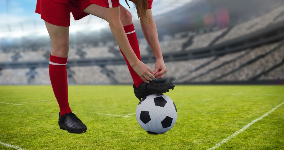 Female Football Player Tying Shoelaces on Soccer Ball