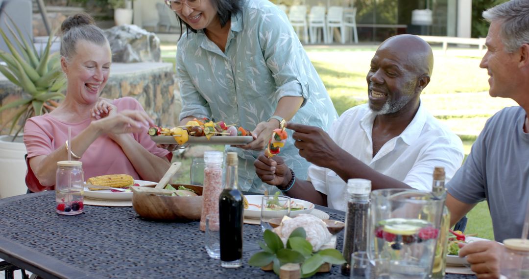 Diverse Friends Enjoying Outdoor Meal with Fresh Skewers