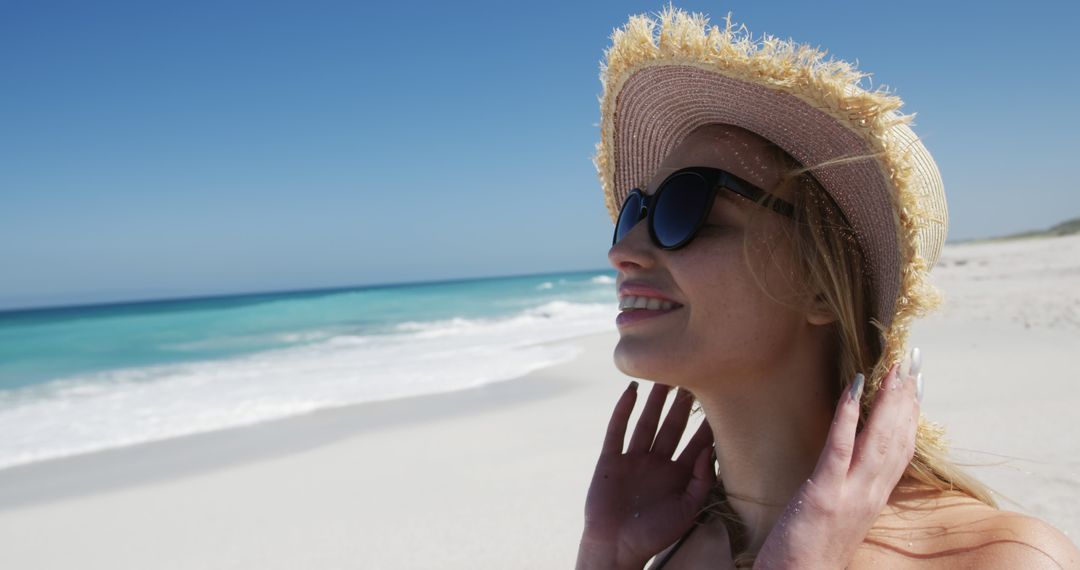 Portrait of happy caucasian woman wearing straw hat by seaside with copy space - Free Images, Stock Photos and Pictures on Pikwizard.com