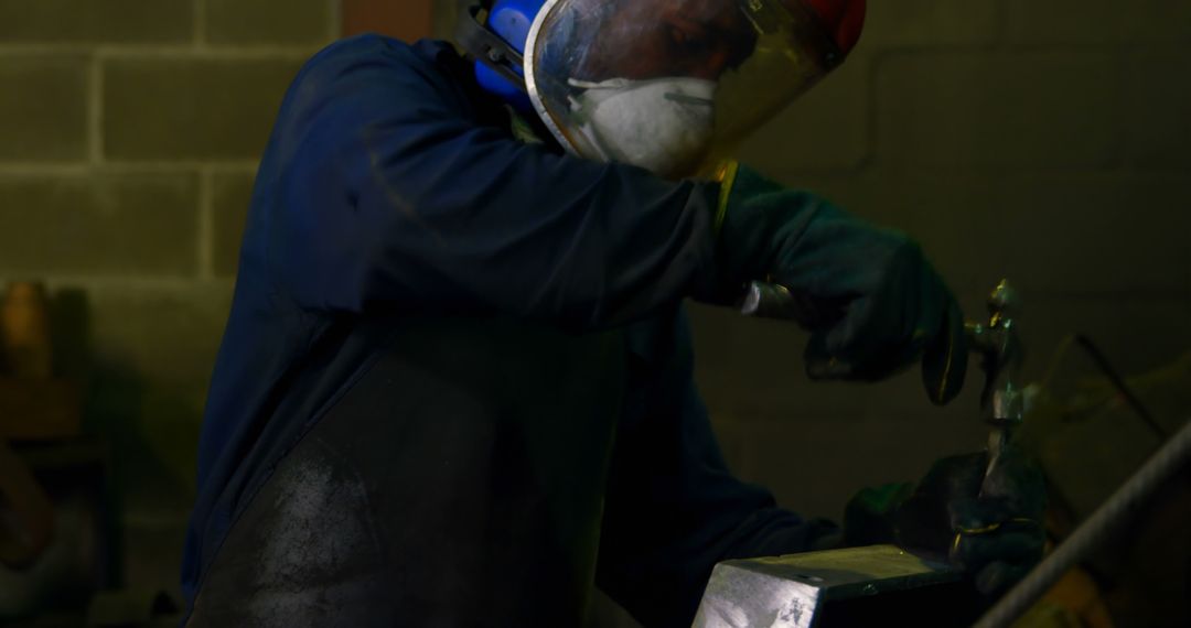 Metalworker Wearing Protective Gear Grinding Metalwork in Workshop - Free Images, Stock Photos and Pictures on Pikwizard.com