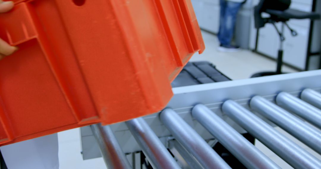 Worker placing red bin onto conveyor belt in warehouse - Free Images, Stock Photos and Pictures on Pikwizard.com