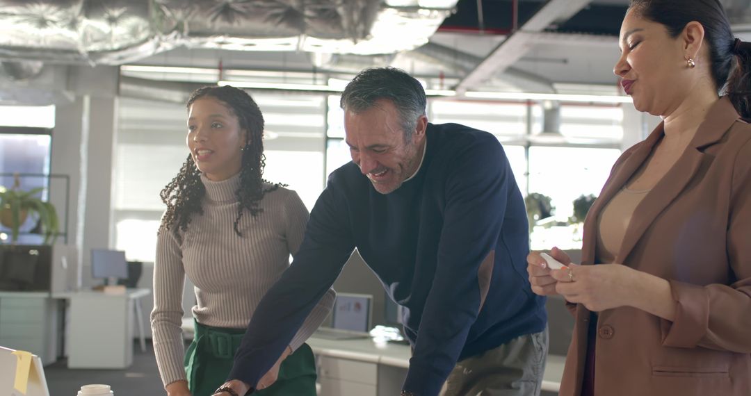 Multicultural team collaborating and brainstorming around desk in modern open-plan office