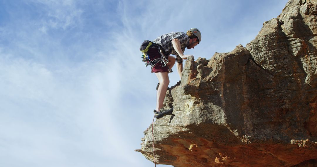 Man Rock Climbing on Cliff Edge with Harness under Clear Sky - Free Images, Stock Photos and Pictures on Pikwizard.com