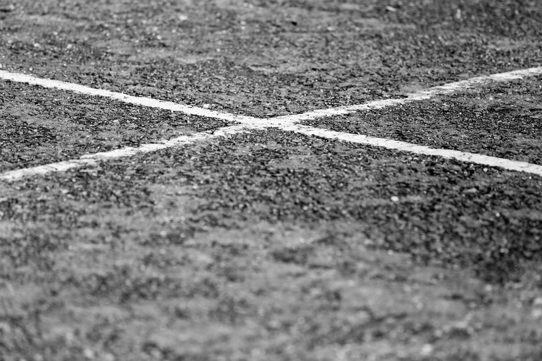 Black and white pavement with cross mark on rough asphalt surface - Free Images, Stock Photos and Pictures on Pikwizard.com