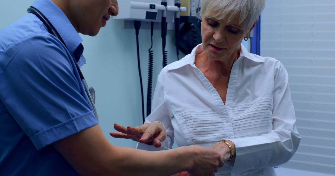 Doctor examining elderly patient's wrist in medical office - Free Images, Stock Photos and Pictures on Pikwizard.com