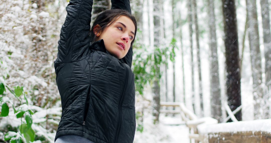 Young woman stretching in winter forest wearing black jacket - Free Images, Stock Photos and Pictures on Pikwizard.com