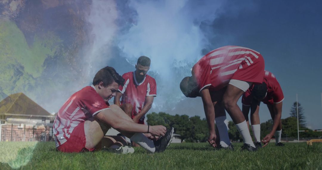 Team Bonding on Soccer Field Tying Shoe Laces in Striped Jerseys