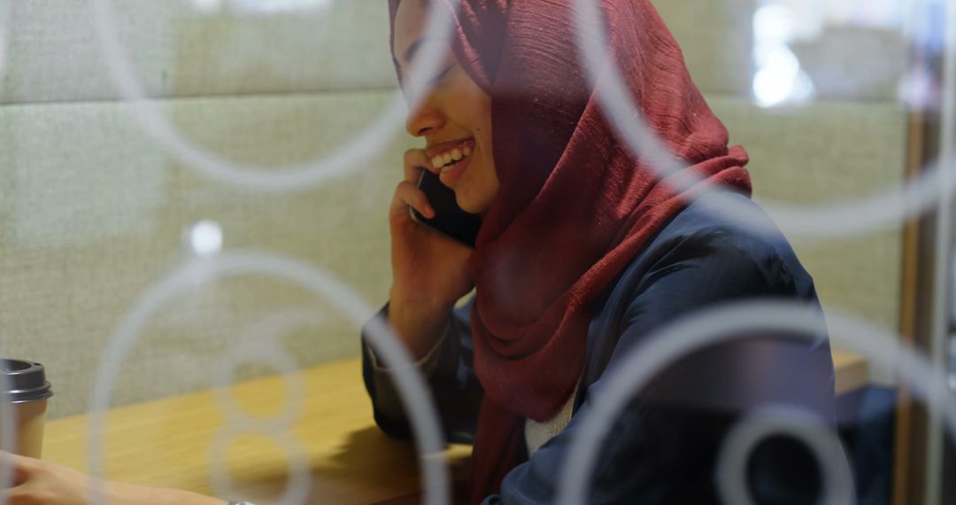 Muslim Woman in Hijab Talking on Phone in Cafe - Free Images, Stock Photos and Pictures on Pikwizard.com