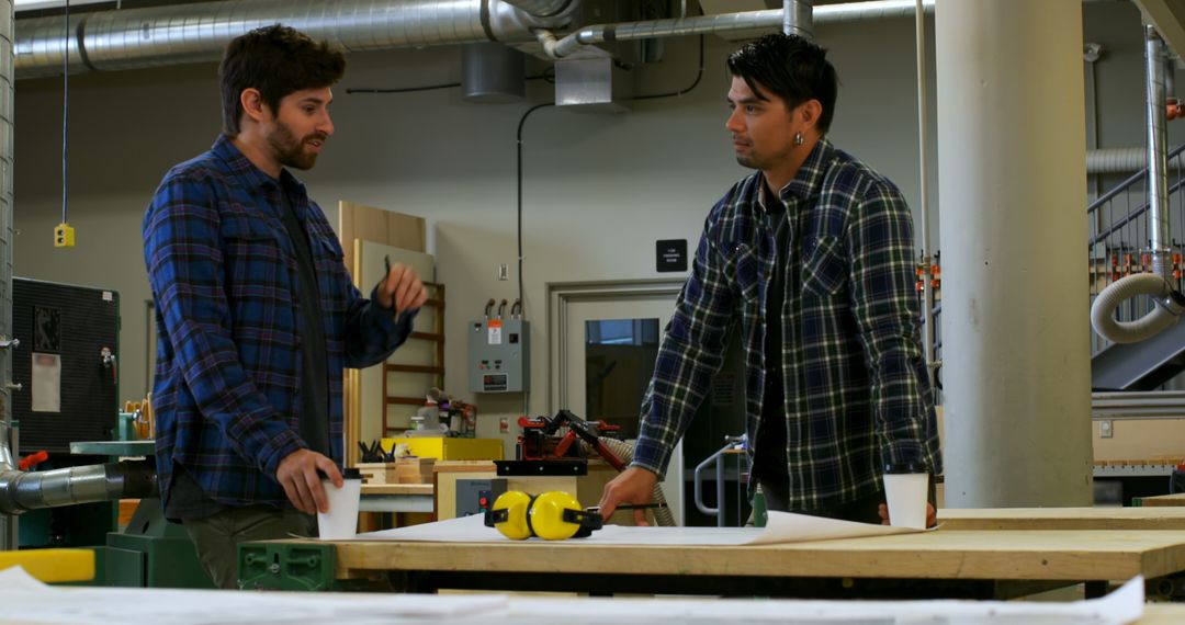 Two Men Having a Discussion in a Workshop - Free Images, Stock Photos and Pictures on Pikwizard.com