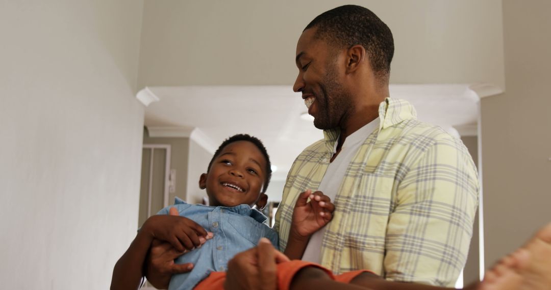 Happy Father Holding Smiling Son in Living Room - Free Images, Stock Photos and Pictures on Pikwizard.com