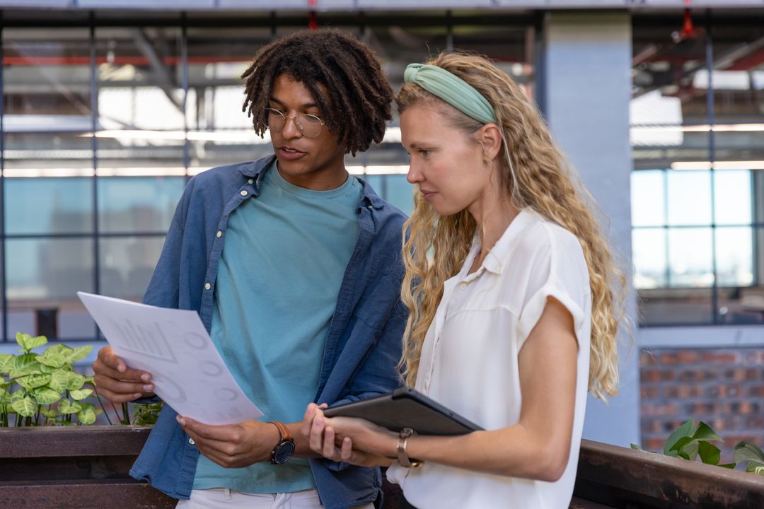 Diverse Coworkers Analyzing Data in Urban Office Setting