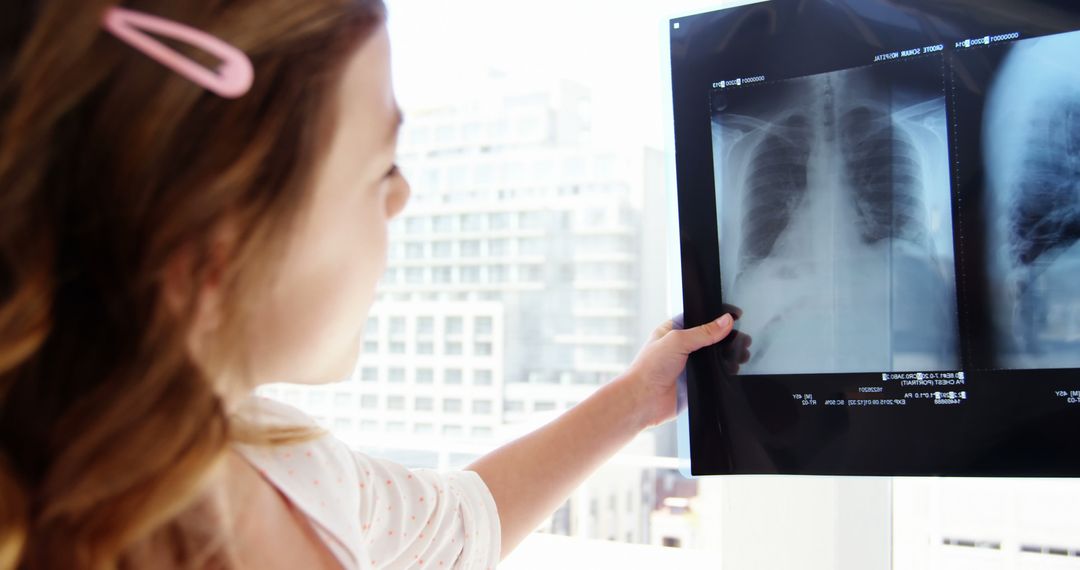 Young Caucasian Girl Looking at Chest X-Ray in Medical Office - Free Images, Stock Photos and Pictures on Pikwizard.com