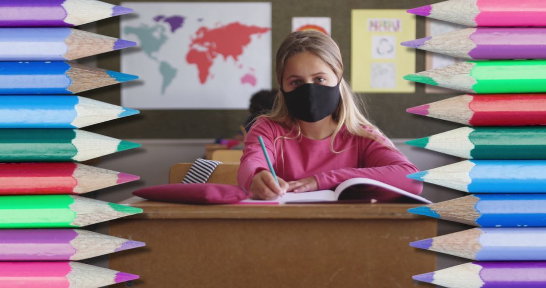 Student Wearing Face Mask Writing in Classroom Surrounded by Colorful Pencils