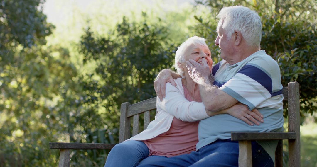 Elderly Couple Embracing on Garden Bench in Sunny Park - Free Images, Stock Photos and Pictures on Pikwizard.com