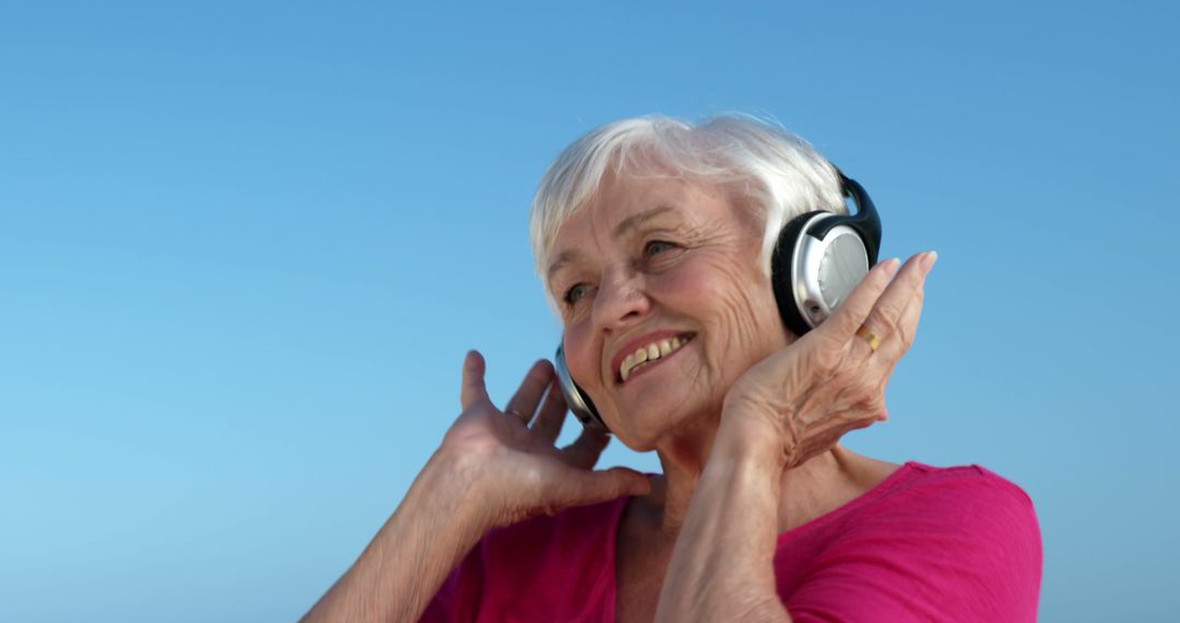 A senior Caucasian woman enjoys listening to music on her headphones, with copy space - Free Images, Stock Photos and Pictures on Pikwizard.com