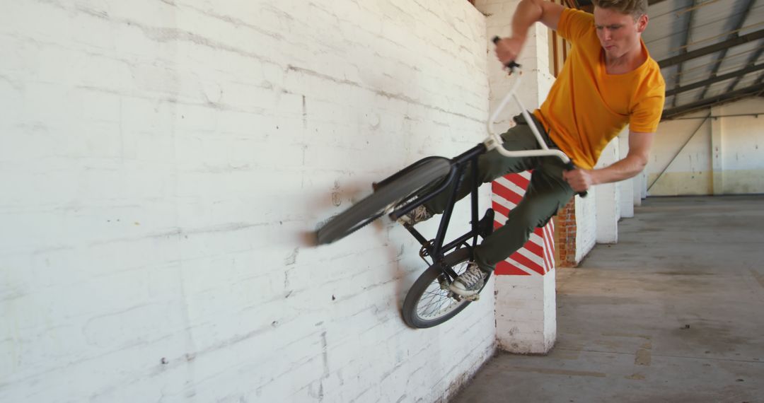 BMX Rider Performing Wall Ride Trick in Urban Warehouse - Free Images, Stock Photos and Pictures on Pikwizard.com