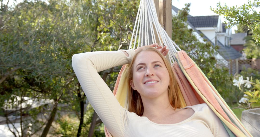 Woman Relaxing in Striped Hammock in Tranquil Backyard Garden