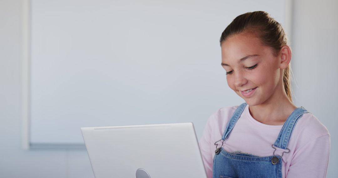 Young Girl Engaging with Laptop Technology in Classroom Setting