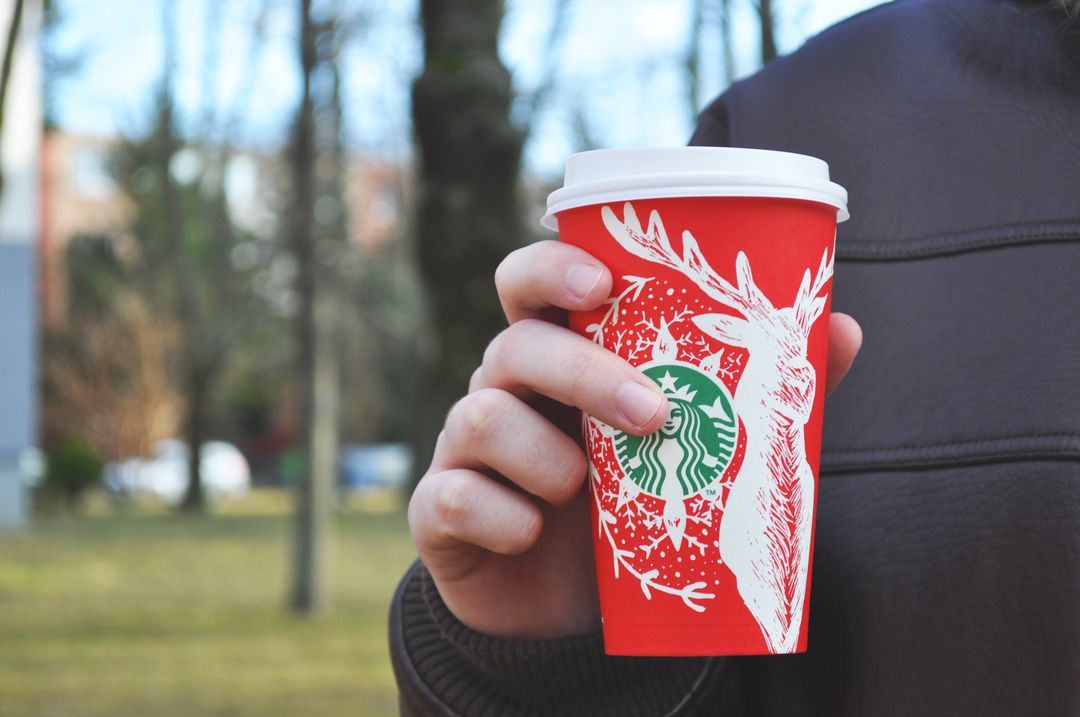 Male Hand Holding Festive Starbucks Red Cup in Park - Free Images, Stock Photos and Pictures on Pikwizard.com