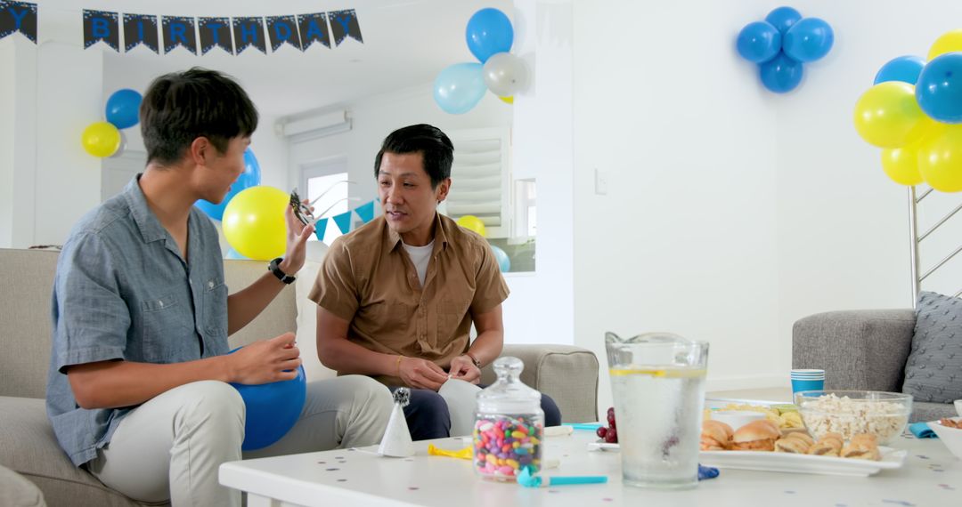 Father and Son Preparing Party with Balloons and Snacks
