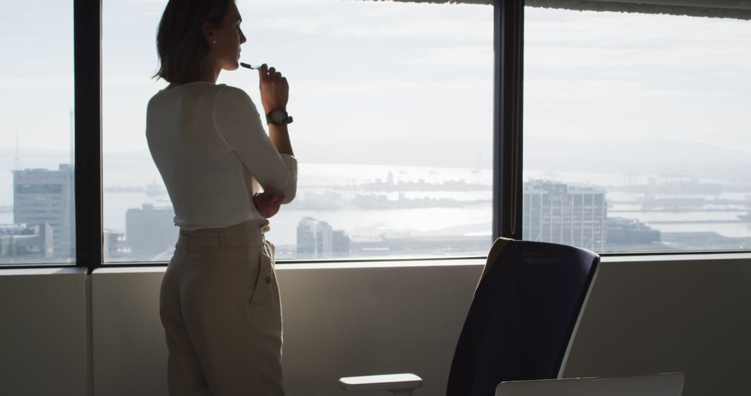 Reflecting businesswoman with cityscape background standing in modern office - Free Images, Stock Photos and Pictures on Pikwizard.com