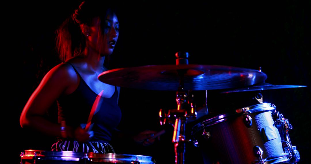 African American female drummer playing drums under stage lights - Free Images, Stock Photos and Pictures on Pikwizard.com