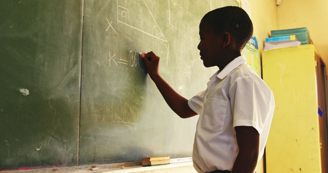Young Boy Solving Math Problemon Chalkboard