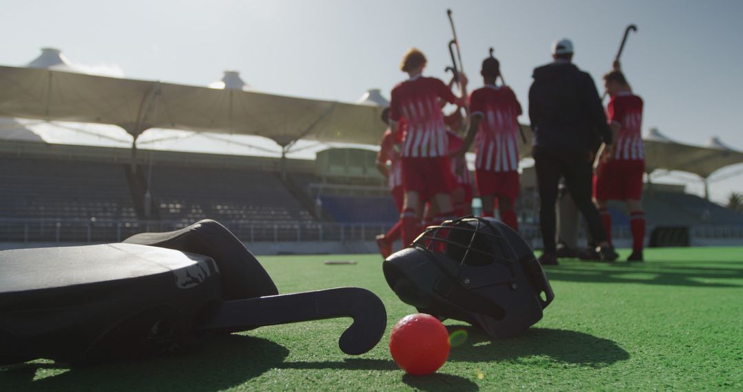 Field Hockey Equipment on Turf with Players in Background - Free Images, Stock Photos and Pictures on Pikwizard.com