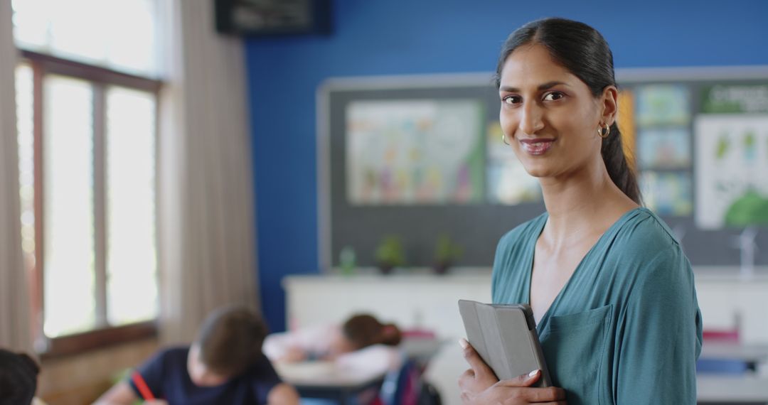 Smiling Female Teacher with Tablet in Engaging Classroom Setting