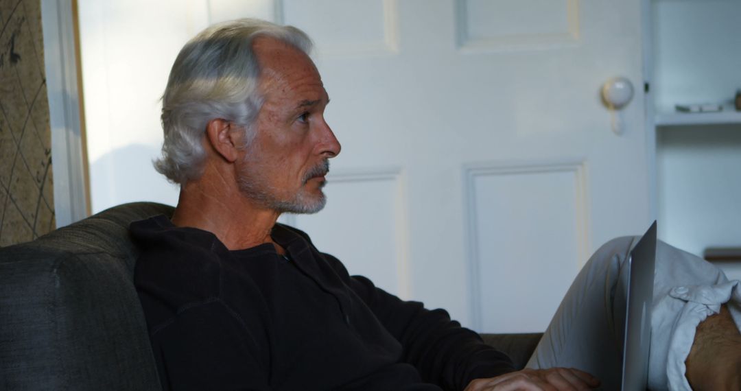 Senior Man Working Remotely on Laptop at Home