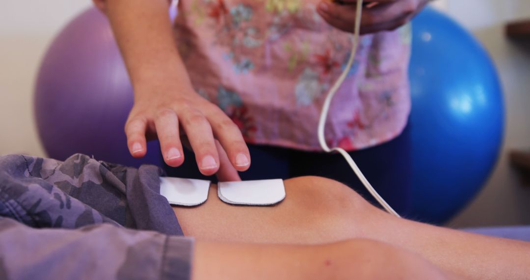 Physical therapist adjusting electrodes on patient's knee - Free Images, Stock Photos and Pictures on Pikwizard.com