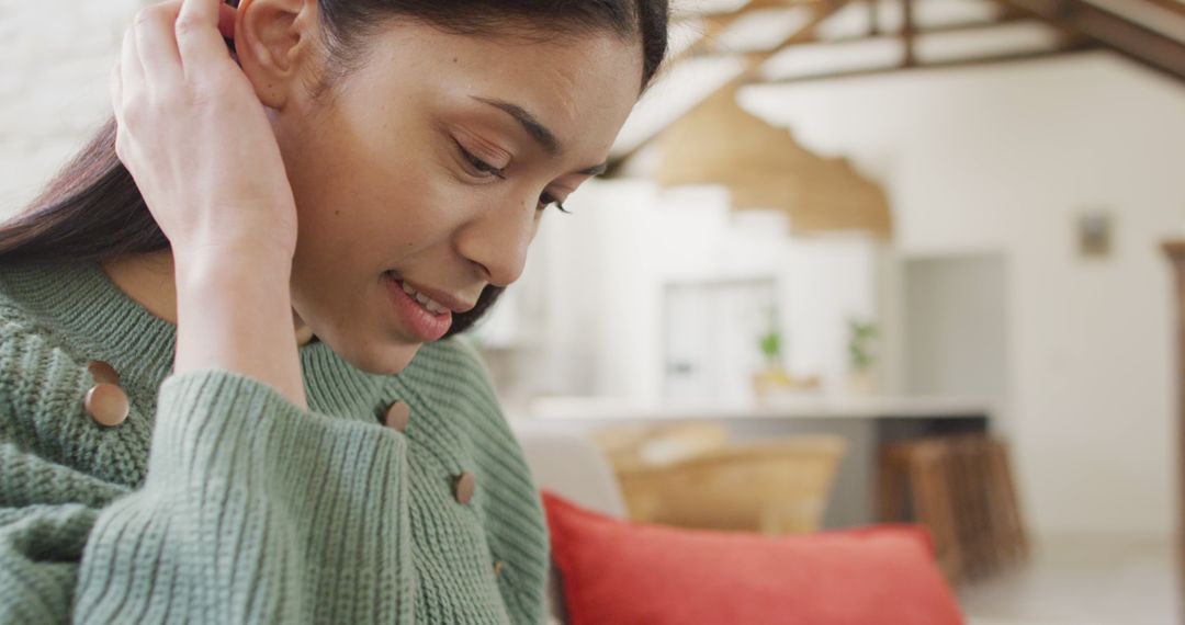 Biracial woman smiling and using smartphone in living room - Free Images, Stock Photos and Pictures on Pikwizard.com