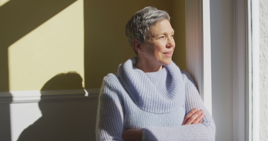 Senior Woman Enjoying Sunlight Through Window - Free Images, Stock Photos and Pictures on Pikwizard.com