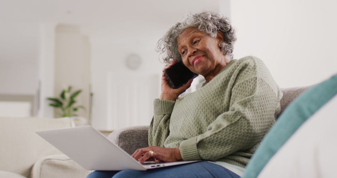 Senior Woman Relaxing with Laptop and Phone on Sofa at Home
