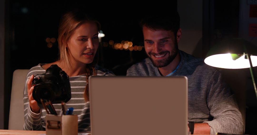 Creative Colleagues Working Late with Laptop and Camera in Office