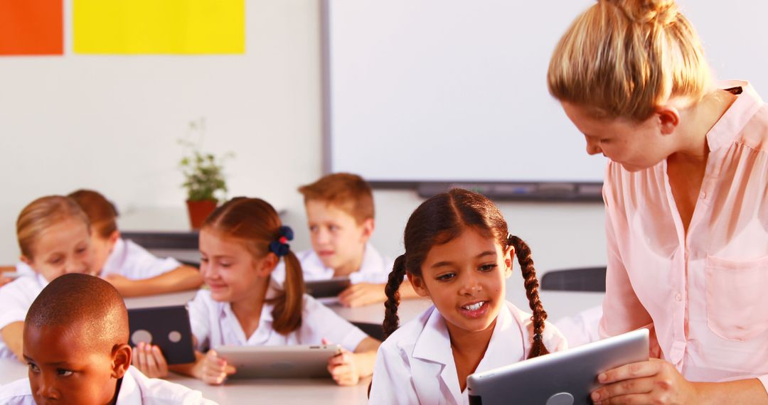 Teacher Helping Schoolchildren Using Tablets in Classroom - Free Images, Stock Photos and Pictures on Pikwizard.com