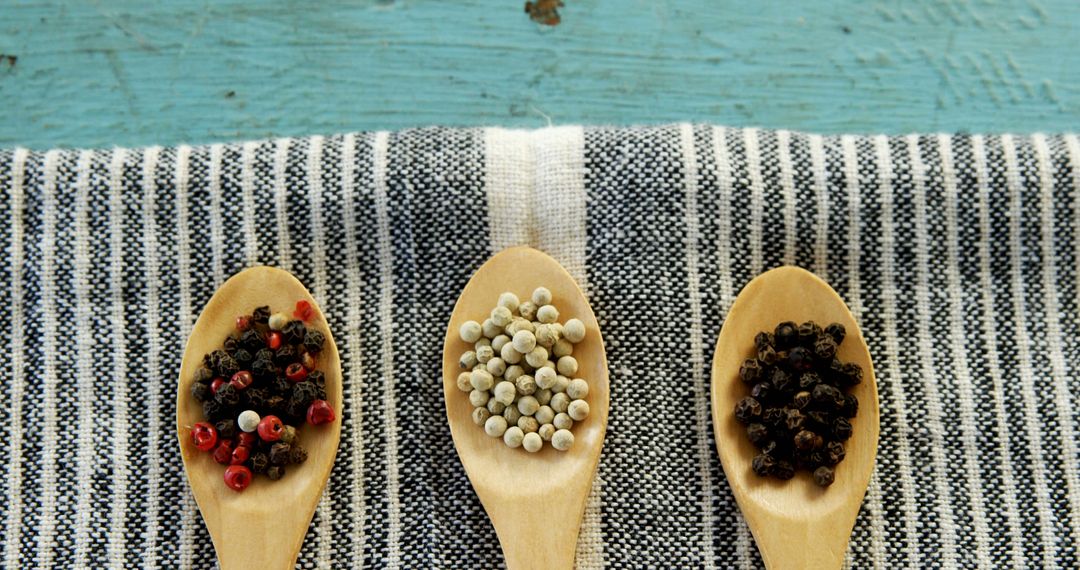 Variety of Peppercorns Neatly Arranged on Rustic Striped Cloth - Free Images, Stock Photos and Pictures on Pikwizard.com