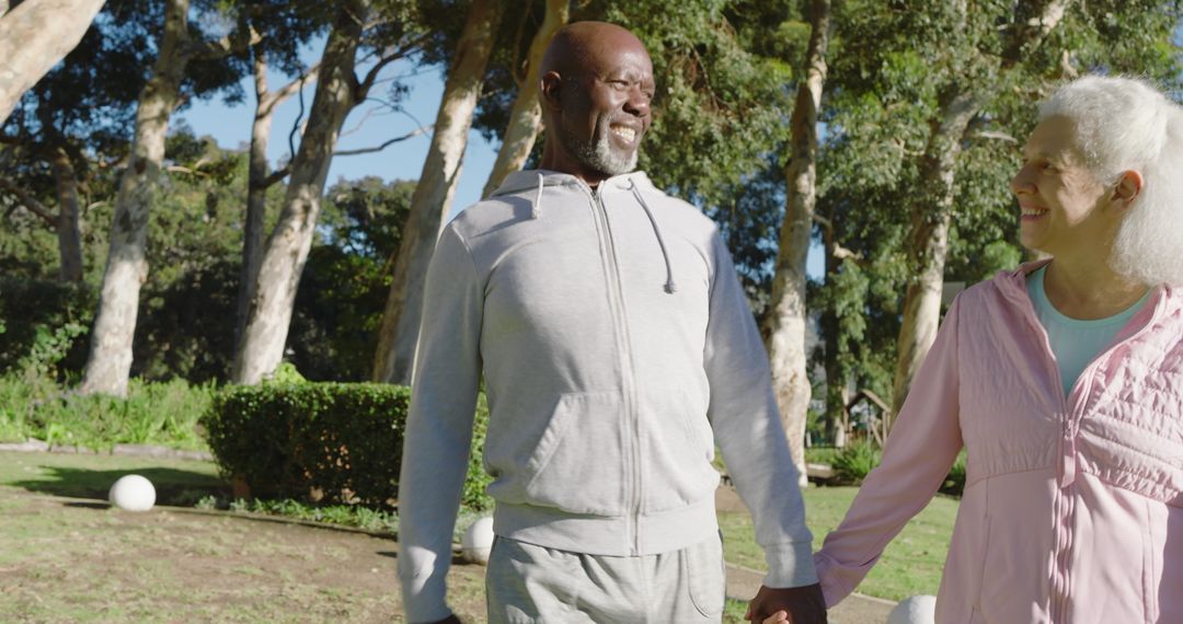 Senior Couple Walking Hand in Hand in Sunny Park Setting