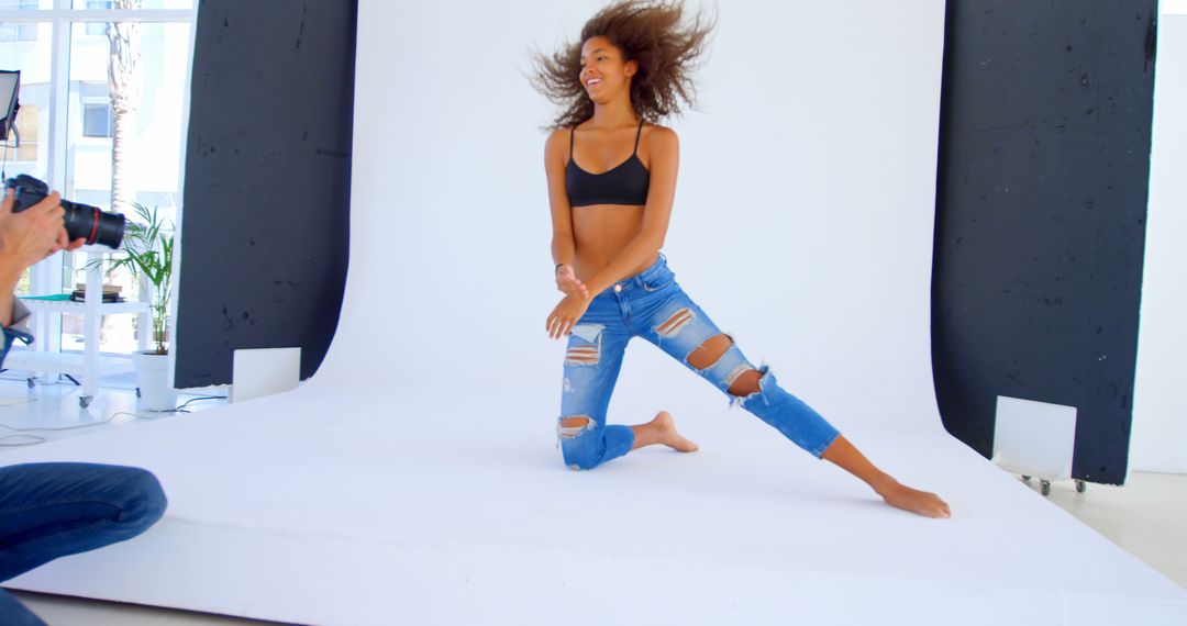 Joyful Young Woman Posing in Studio During Photo Shoot - Free Images, Stock Photos and Pictures on Pikwizard.com