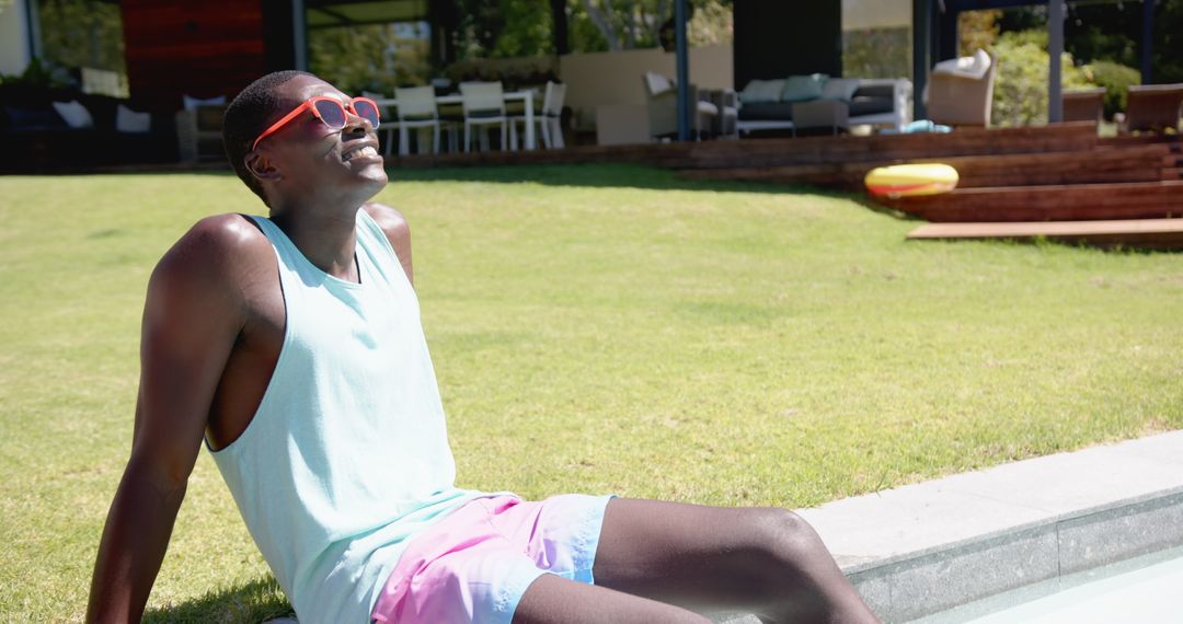 Man Relaxing Poolside in Sunglasses on Sunny Day