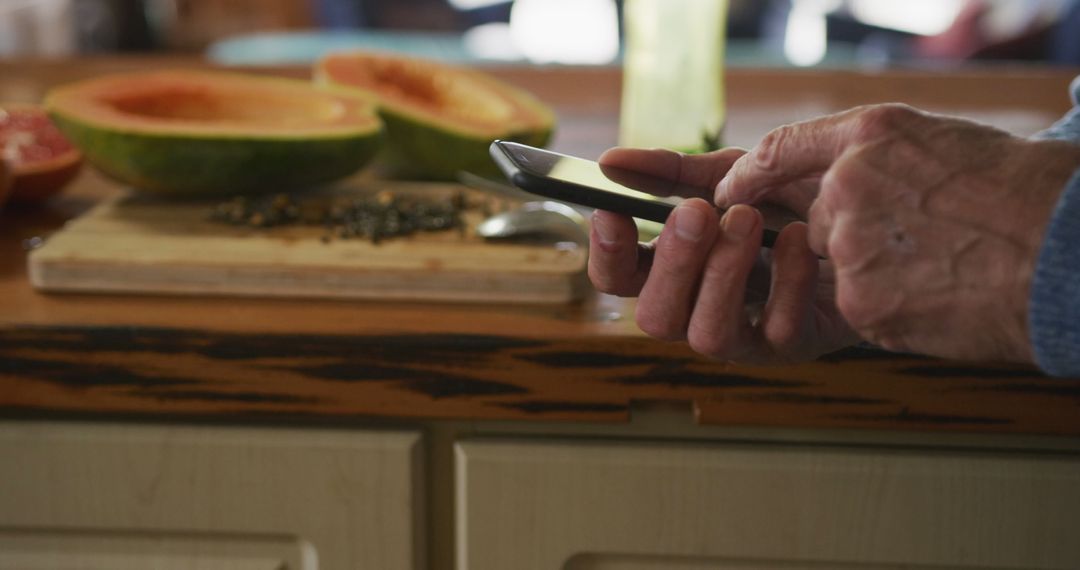 Senior Man Using Smartphone in Kitchen with Fruit - Free Images, Stock Photos and Pictures on Pikwizard.com